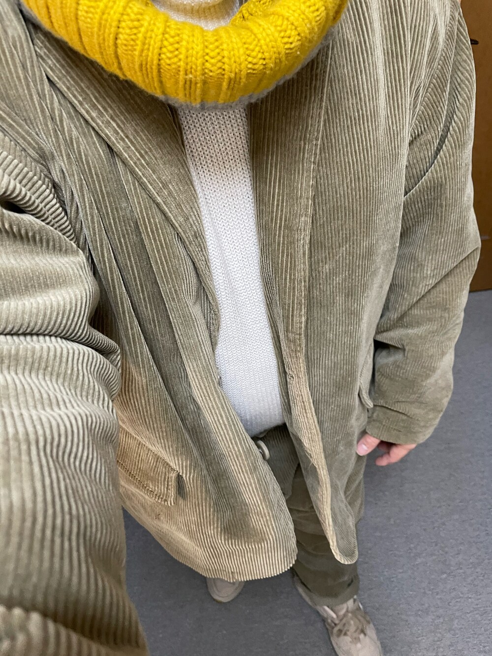 ホワイト系のニット/セーター、ベージュ系のテーラードジャケット、ベージュ系のスニーカーを着用したメンズの冬コーディネートの2枚目の写真