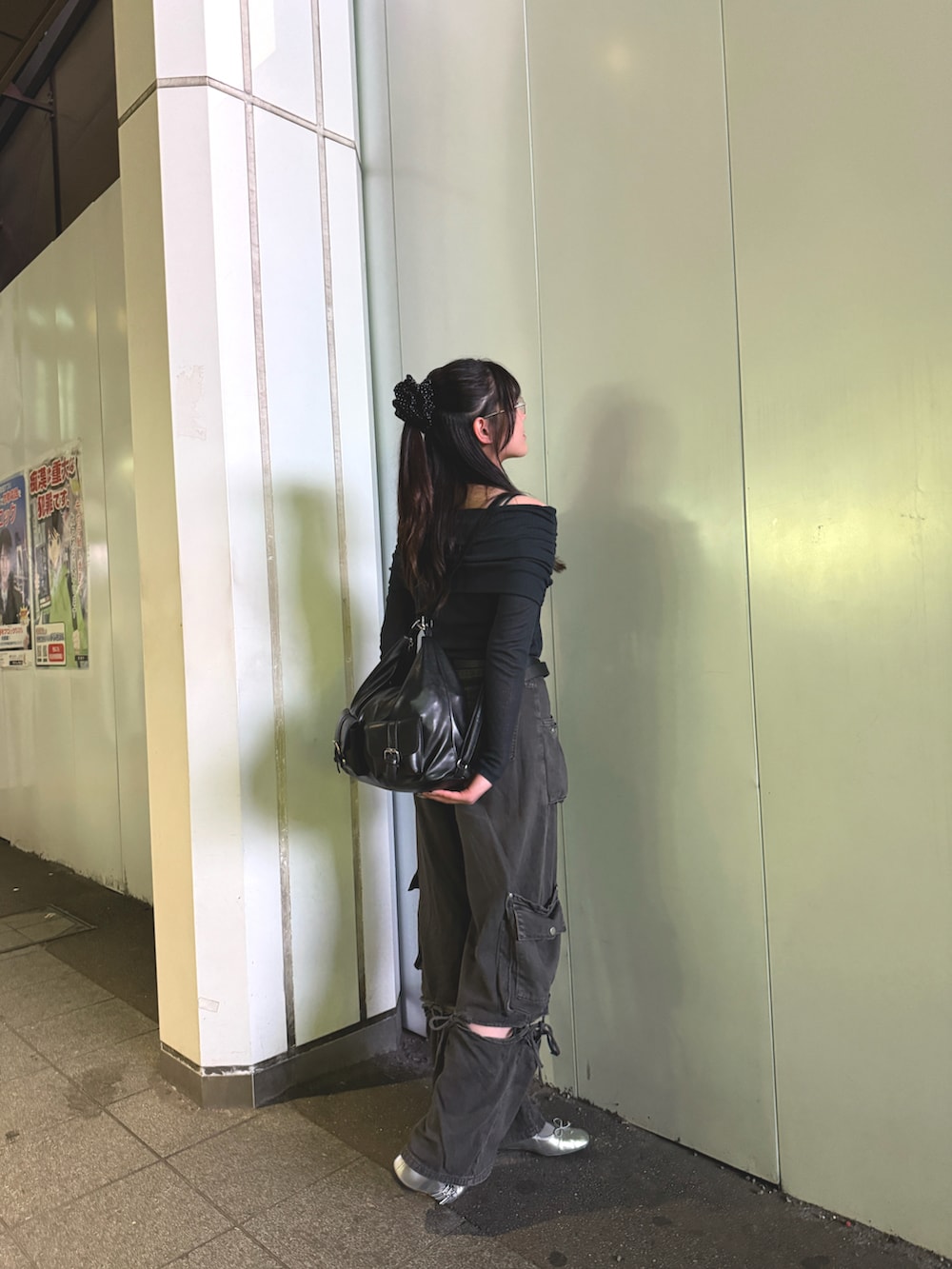 ブラック系のショルダーバッグ、グレー系のカーゴパンツ、シルバー系のバレエシューズを着用したレディースの春コーディネートの2枚目の写真