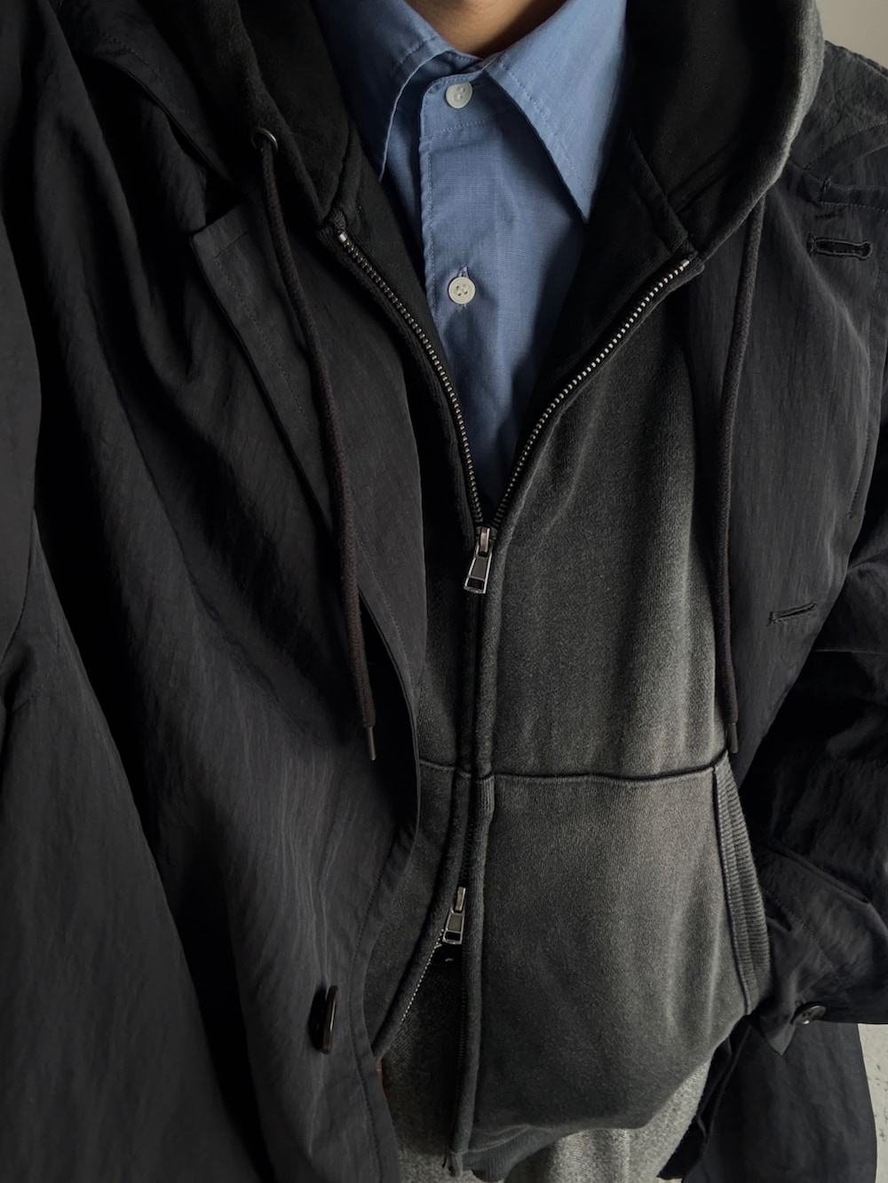 ブラック系のパーカー、ブルー系のシャツ/ブラウス、グレー系のパンツを着用したメンズの冬コーディネートの3枚目の写真