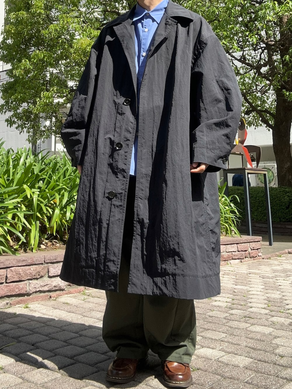 ブルー系のシャツ/ブラウス、グリーン系のその他パンツ、ブラウン系のドレスシューズを着用したメンズの春コーディネートの3枚目の写真