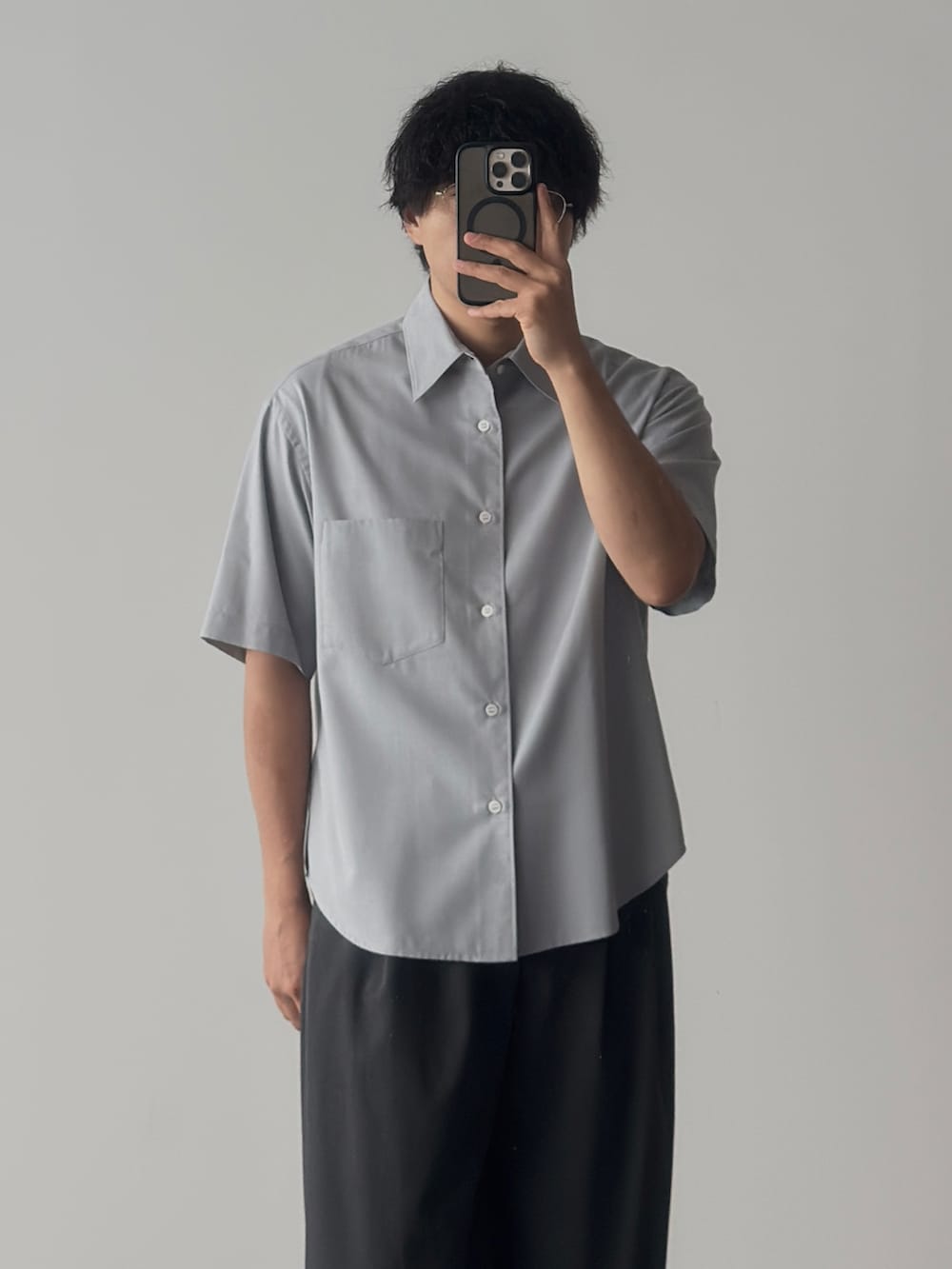 ブルー系のシャツ/ブラウス、ブラック系のスニーカー、グレー系のスラックスを着用したメンズの夏コーディネートの3枚目の写真