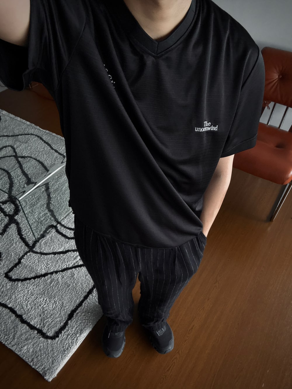 ブラック系のTシャツ/カットソー、ブラック系のスニーカー、ブラック系のスラックスを着用したメンズの夏コーディネートの2枚目の写真