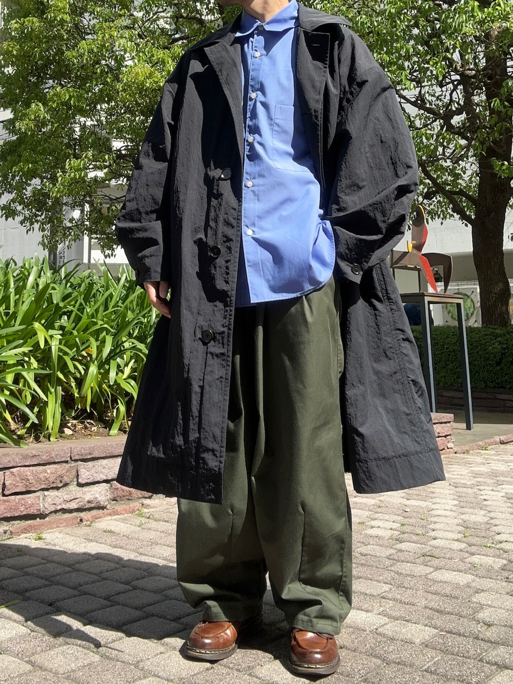 ブルー系のシャツ/ブラウス、グリーン系のその他パンツ、ブラウン系のドレスシューズを着用したメンズの春コーディネートの2枚目の写真