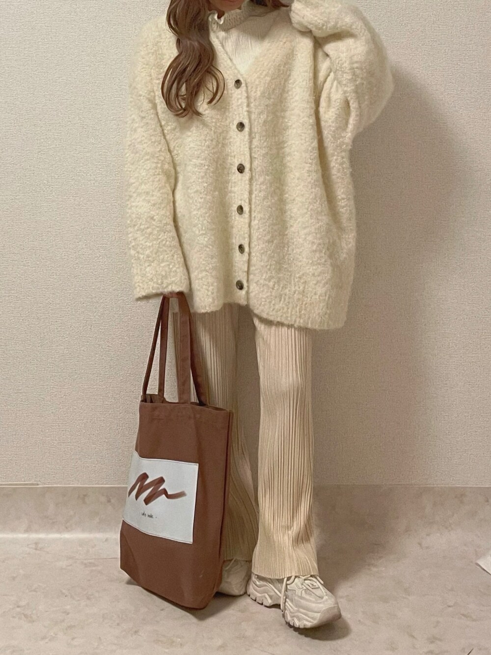 ホワイト系のカーディガン/ボレロ、ホワイト系のその他パンツ、ブラウン系のトートバッグを着用したレディースの秋コーディネートの2枚目の写真