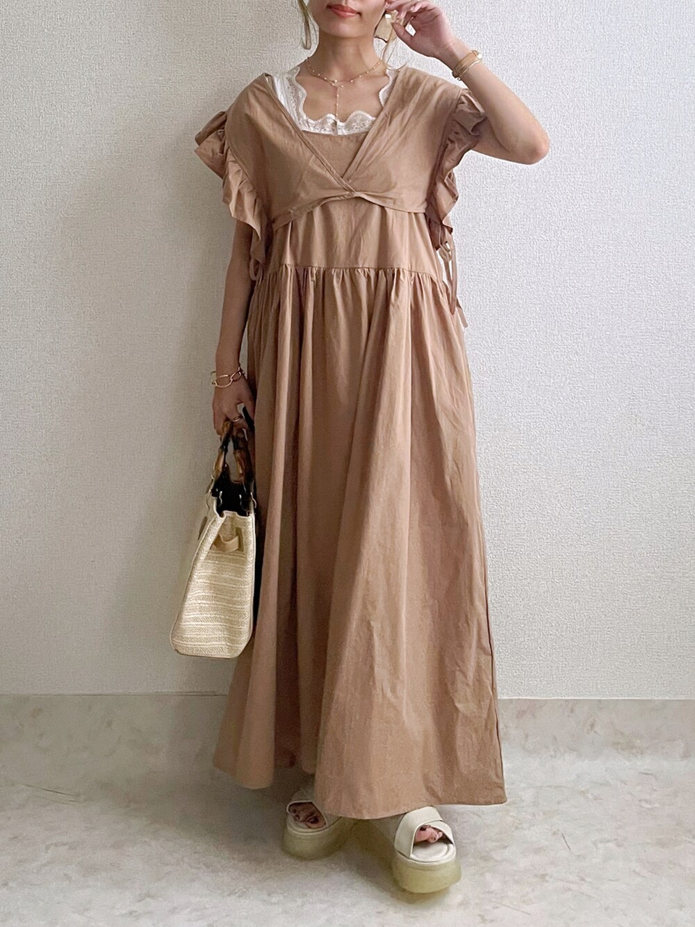 ベージュ系のワンピース、ホワイト系のタンクトップ、ホワイト系のショルダーバッグを着用したレディースの夏コーディネートの2枚目の写真