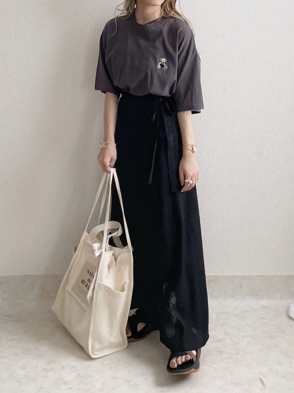 ブラウン系のボディバッグ/ウエストポーチ、グレー系のTシャツ/カットソー、ブラック系のスカートを着用したレディースの秋コーディネートの2枚目の写真