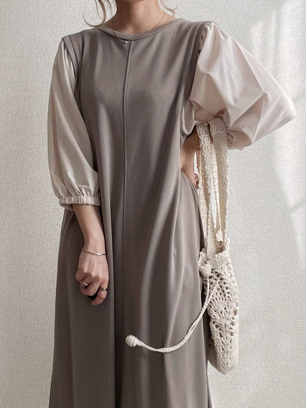 ベージュ系のワンピース、ホワイト系のトートバッグ、ブラック系のスニーカーを着用したレディースの秋コーディネートの2枚目の写真