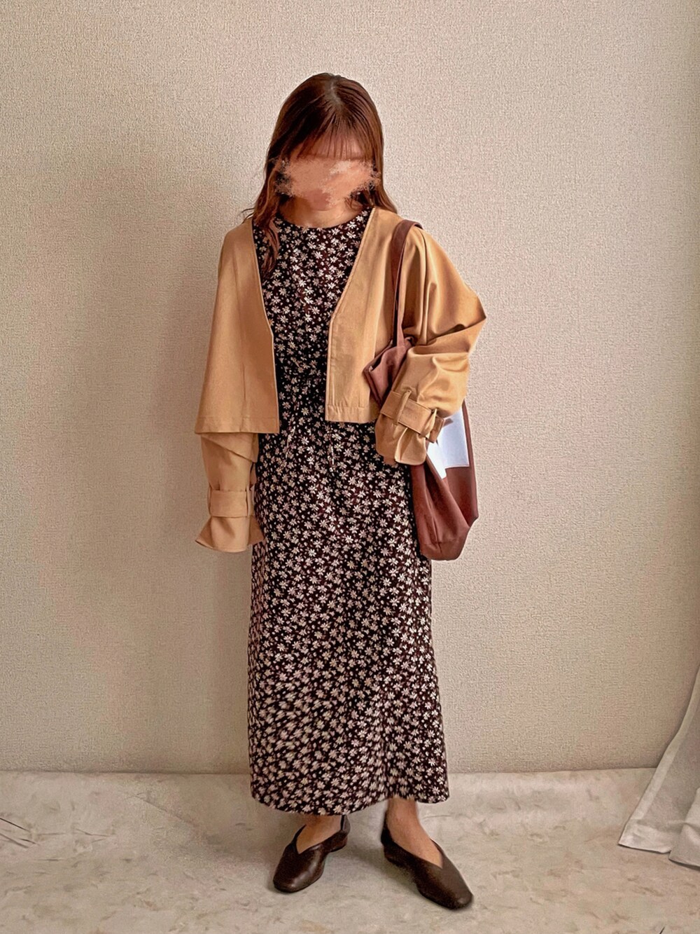 ベージュ系のトレンチコート、ブラウン系のトートバッグ、ブラウン系のワンピースを着用したレディースの春コーディネートの2枚目の写真