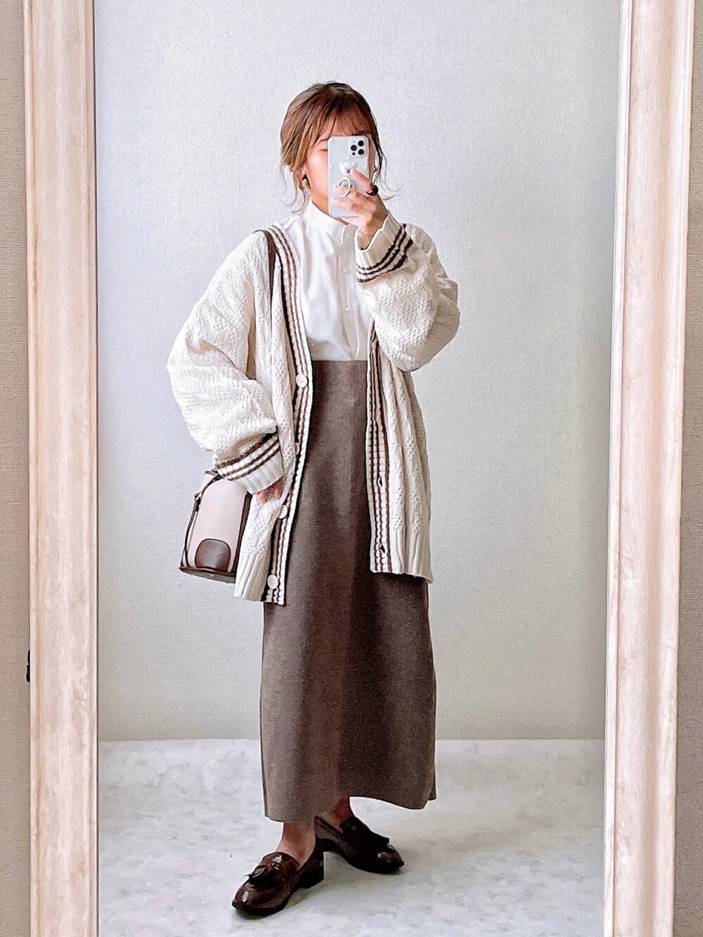 ホワイト系のカーディガン/ボレロ、ホワイト系のシャツ/ブラウス、ブラウン系のスカートを着用したレディースの秋コーディネートの2枚目の写真