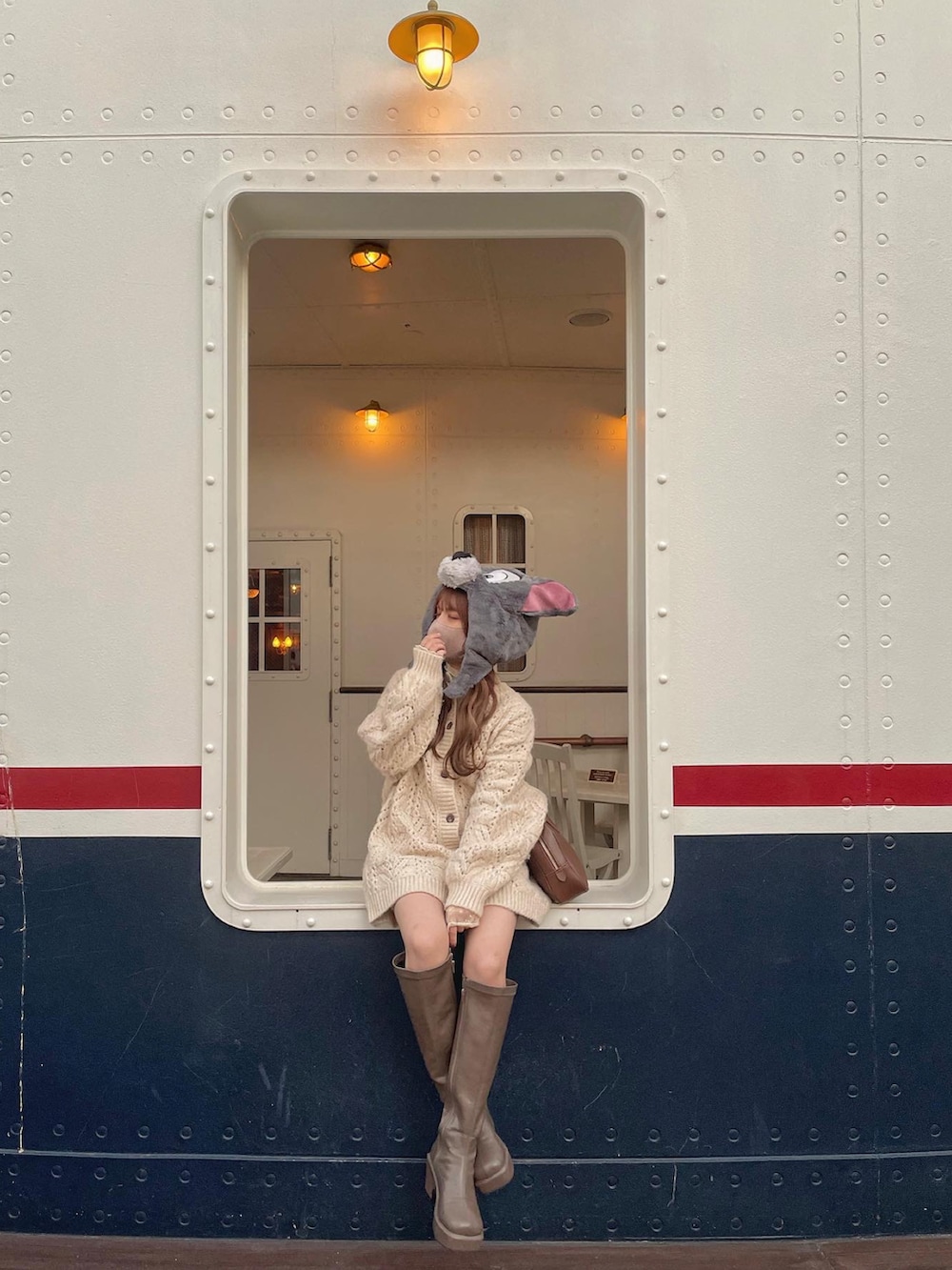 ホワイト系のトップス、ベージュ系のシャツ/ブラウス、ブラウン系のボストンバッグを着用したレディースの冬コーディネートの2枚目の写真