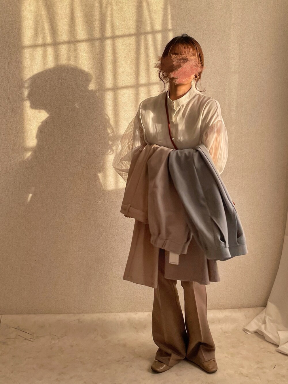 ホワイト系のシャツ/ブラウス、ベージュ系のハンドバッグ、グレー系のパンツを着用したレディースの冬コーディネートの2枚目の写真