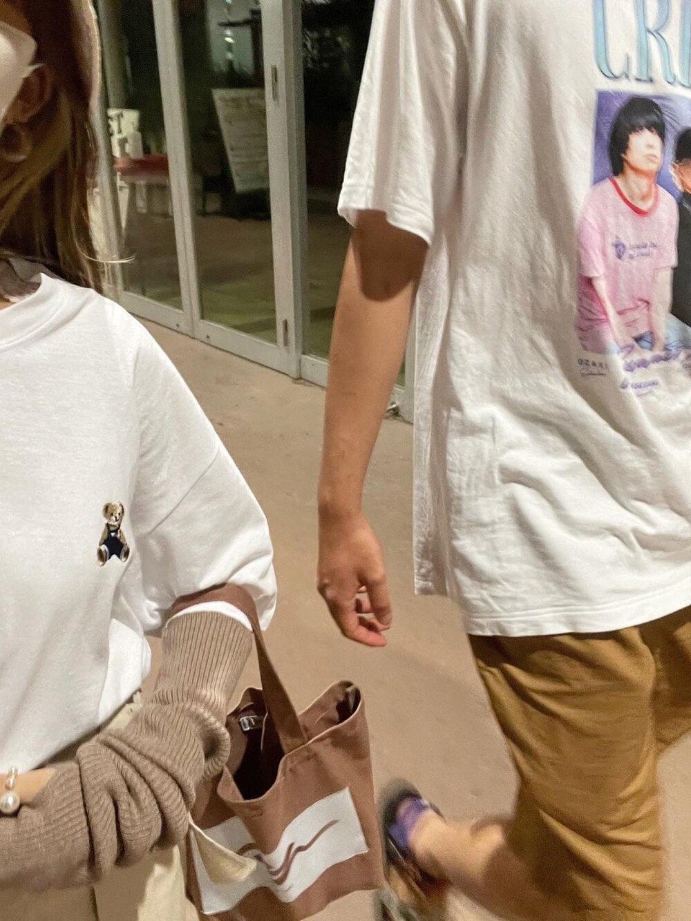 ブラウン系のトートバッグ、ベージュ系のスカート、ブラウン系のアームカバーを着用したレディースの秋コーディネートの2枚目の写真