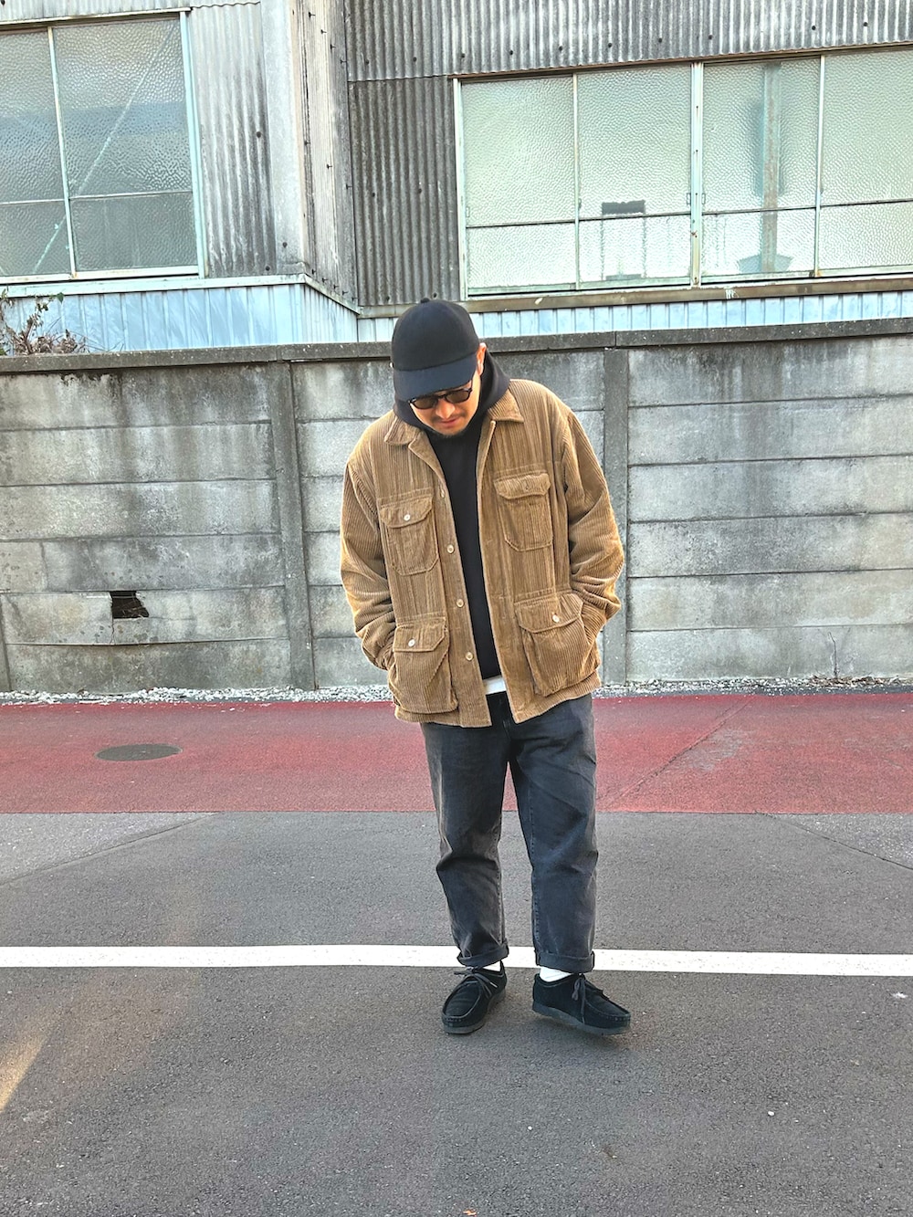 ブラック系のパーカー、ブラウン系のジャケット/アウター、グレー系のデニムパンツを着用したメンズの秋コーディネートの2枚目の写真