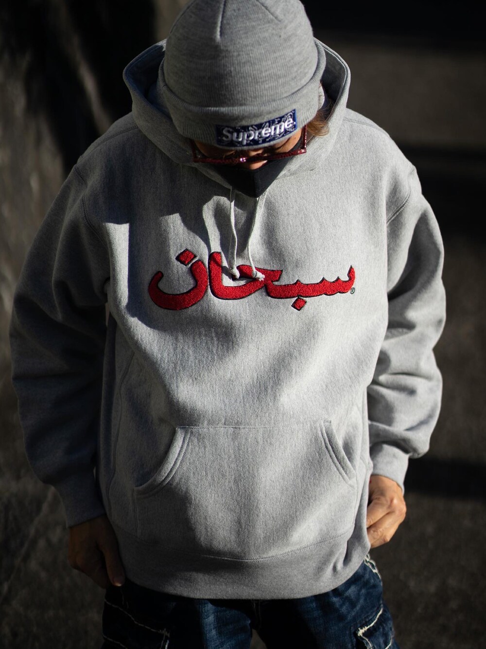 グレー系のパーカー、ブルー系のデニムパンツ、グレー系のスニーカーを着用したメンズの冬コーディネートの2枚目の写真