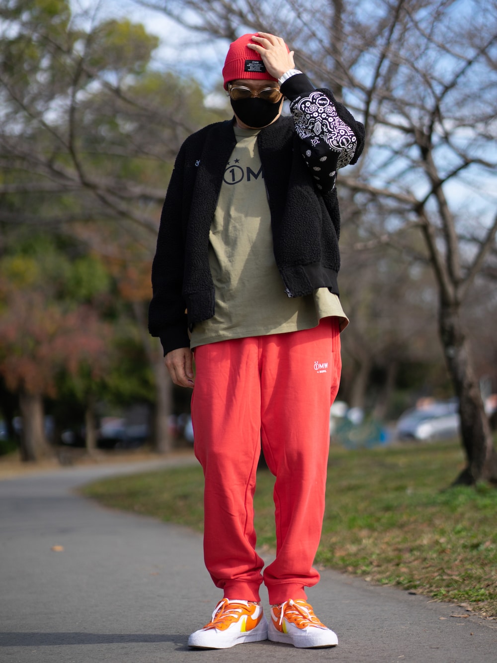 ブラック系のミリタリージャケット、ベージュ系のTシャツ/カットソー、オレンジ系のパンツを着用したメンズの秋コーディネートの3枚目の写真