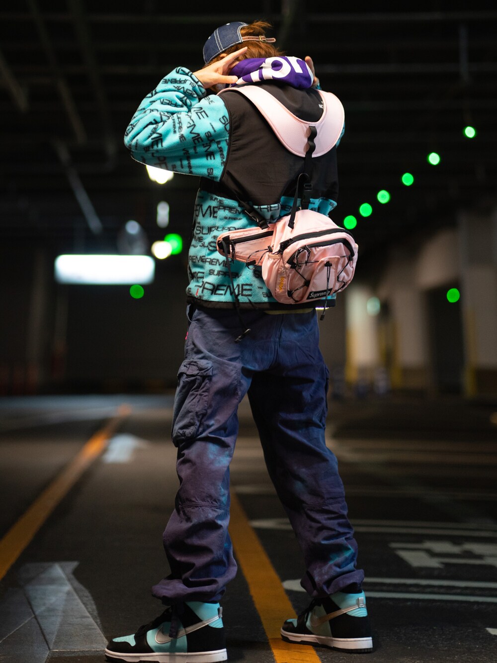 ブルー系のマウンテンパーカー、ブルー系のカーゴパンツ、ピンク系のショルダーバッグを着用したメンズの春コーディネートの3枚目の写真