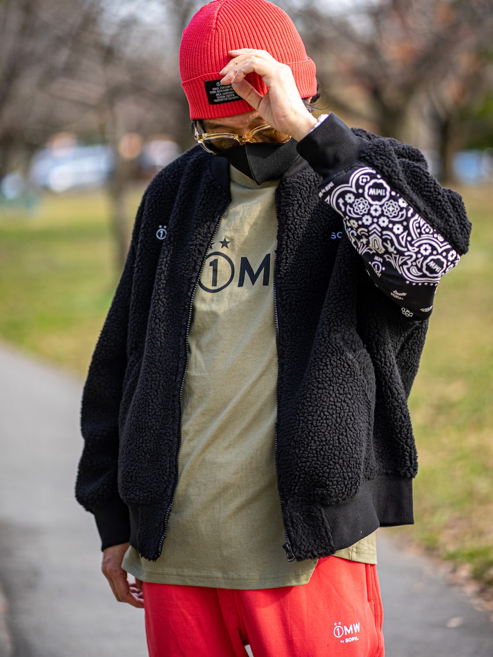 ブラック系のミリタリージャケット、ベージュ系のTシャツ/カットソー、オレンジ系のパンツを着用したメンズの秋コーディネートの4枚目の写真