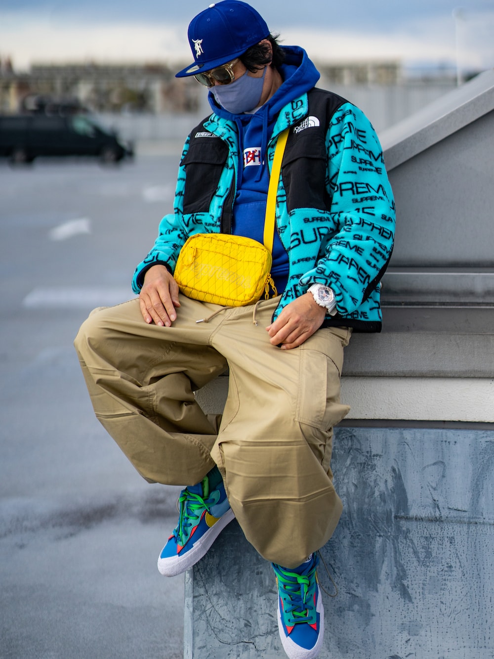 ブルー系のマウンテンパーカー、ベージュ系のカーゴパンツ、ブルー系のスニーカーを着用したメンズの冬コーディネートの2枚目の写真