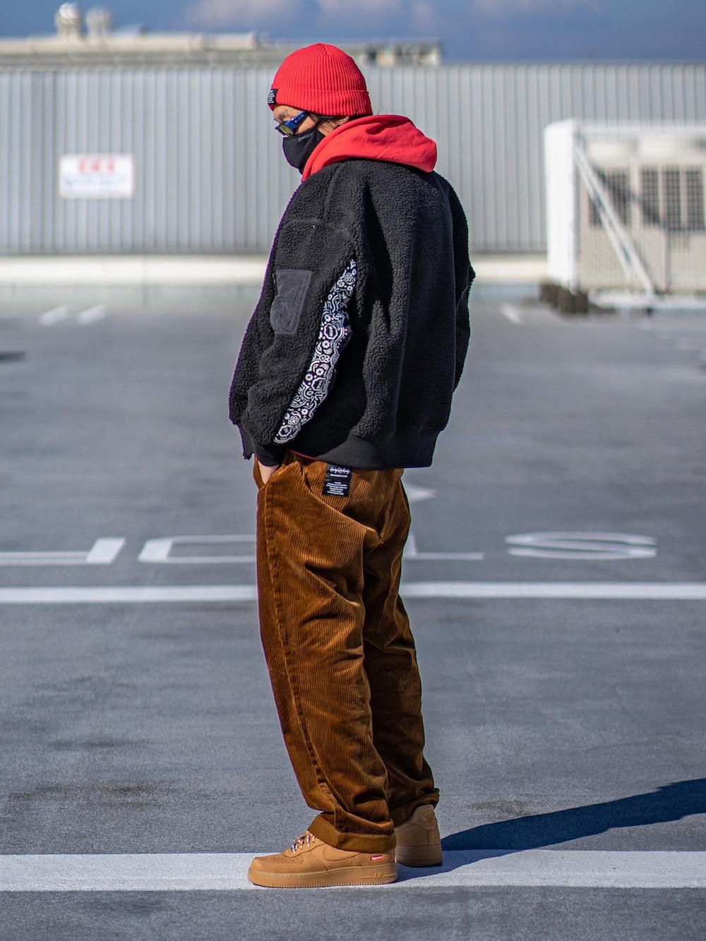 ブラック系のミリタリージャケット、オレンジ系のパンツ、ブラウン系のパンツを着用したメンズの秋コーディネートの3枚目の写真