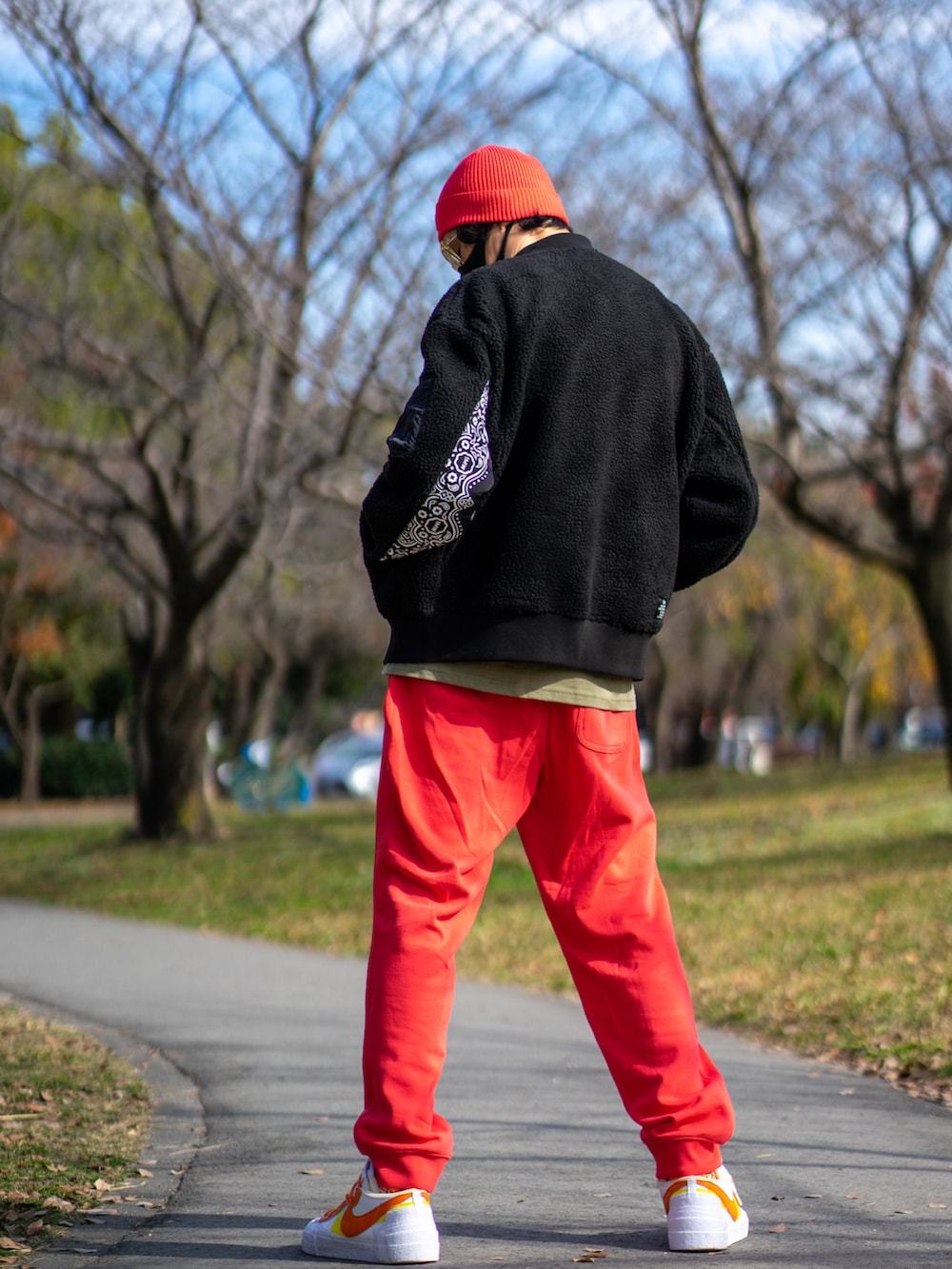 ブラック系のミリタリージャケット、ベージュ系のTシャツ/カットソー、オレンジ系のパンツを着用したメンズの秋コーディネートの2枚目の写真