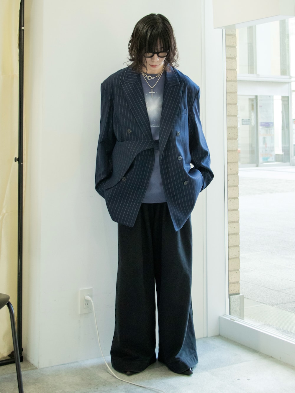 ブルー系のテーラードジャケット、ブラック系のスウェットパンツ、ブラック系のブーツを着用したメンズの春コーディネートの2枚目の写真