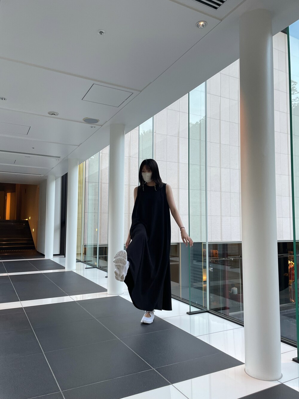 ブラック系のワンピース、ホワイト系のスニーカー、その他のマスクを着用したレディースの夏コーディネートの3枚目の写真