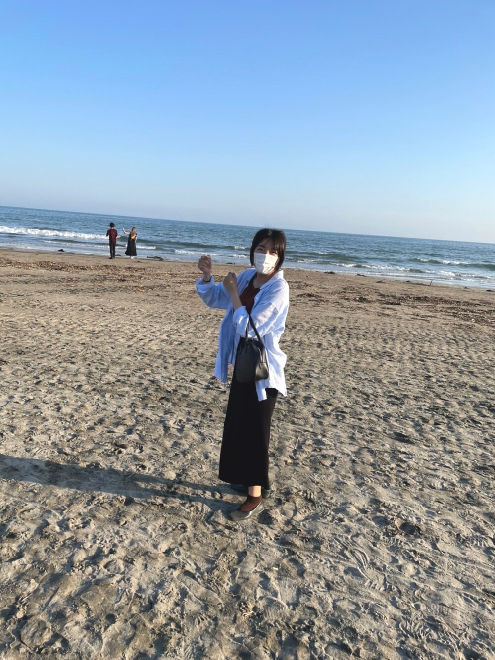 ブルー系のシャツ/ブラウス、ブラック系のトートバッグ、ブラック系のスカートを着用したレディースの春コーディネートの2枚目の写真