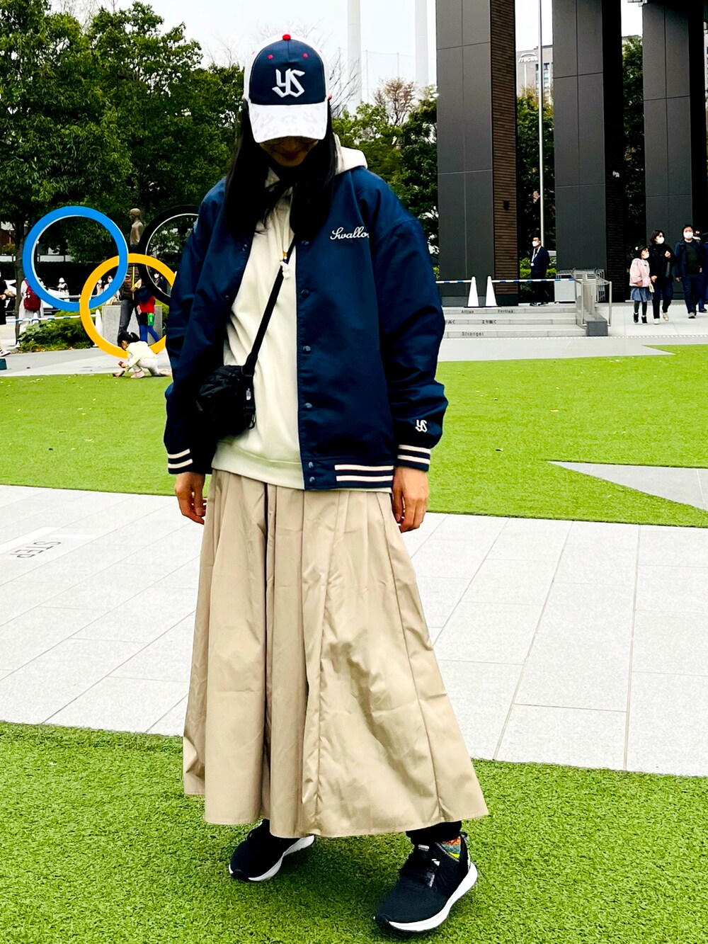 ブルー系のジャケット/アウター、ホワイト系のパーカー、ブラック系のスニーカーを着用したレディースの春コーディネートの2枚目の写真