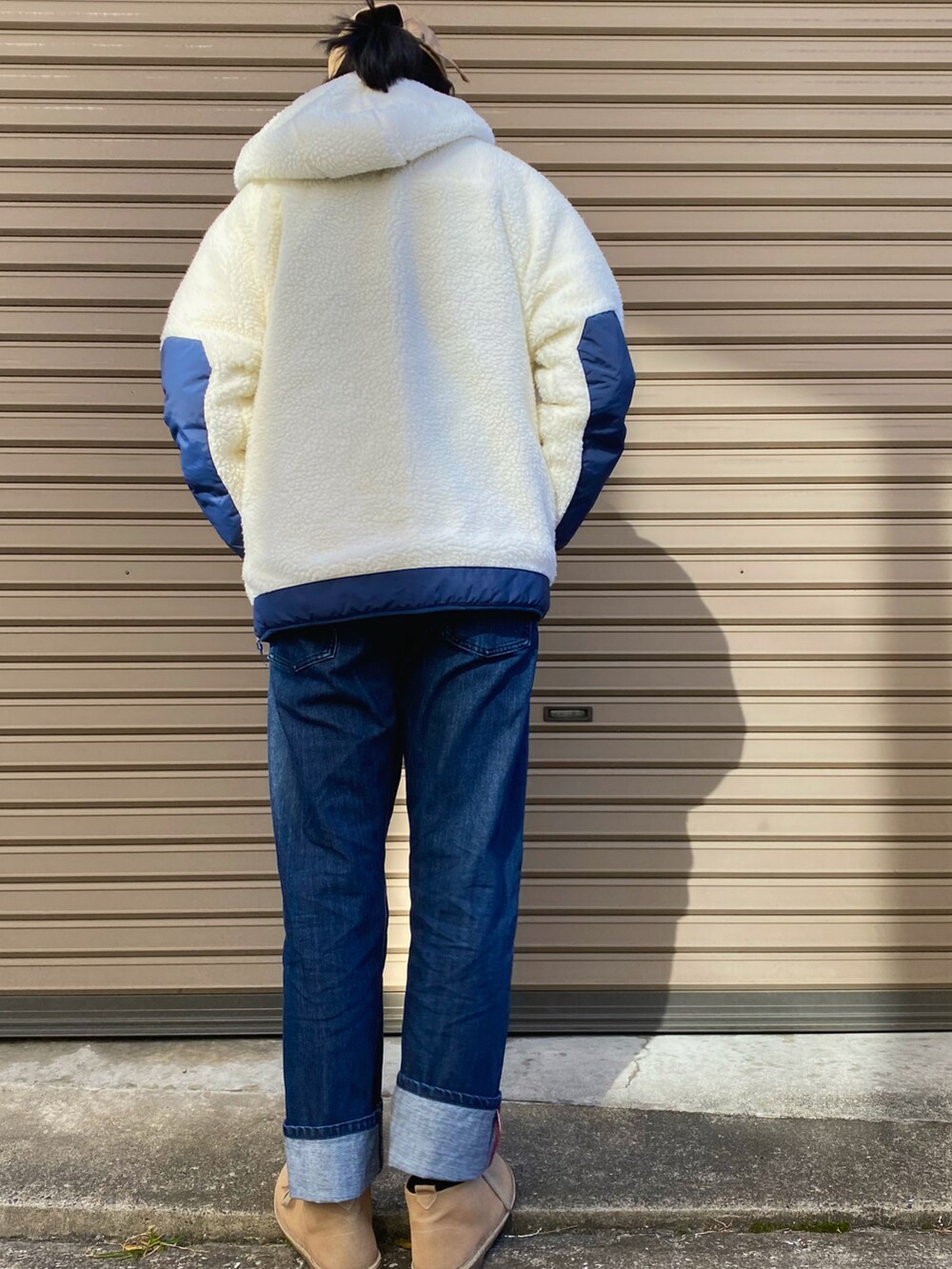 ブルー系のニット/セーター、ホワイト系のブルゾン、ブルー系のデニムパンツを着用したレディースの秋コーディネートの2枚目の写真