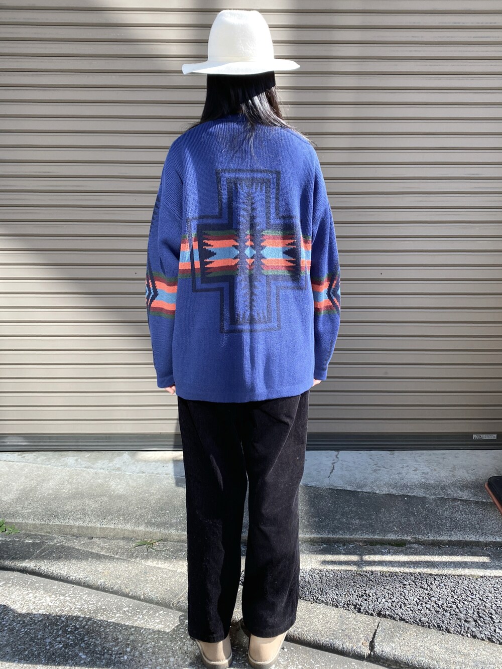 ブラック系のパンツ、ホワイト系のTシャツ/カットソー、グレー系のカーディガン/ボレロを着用したレディースの秋コーディネートの2枚目の写真