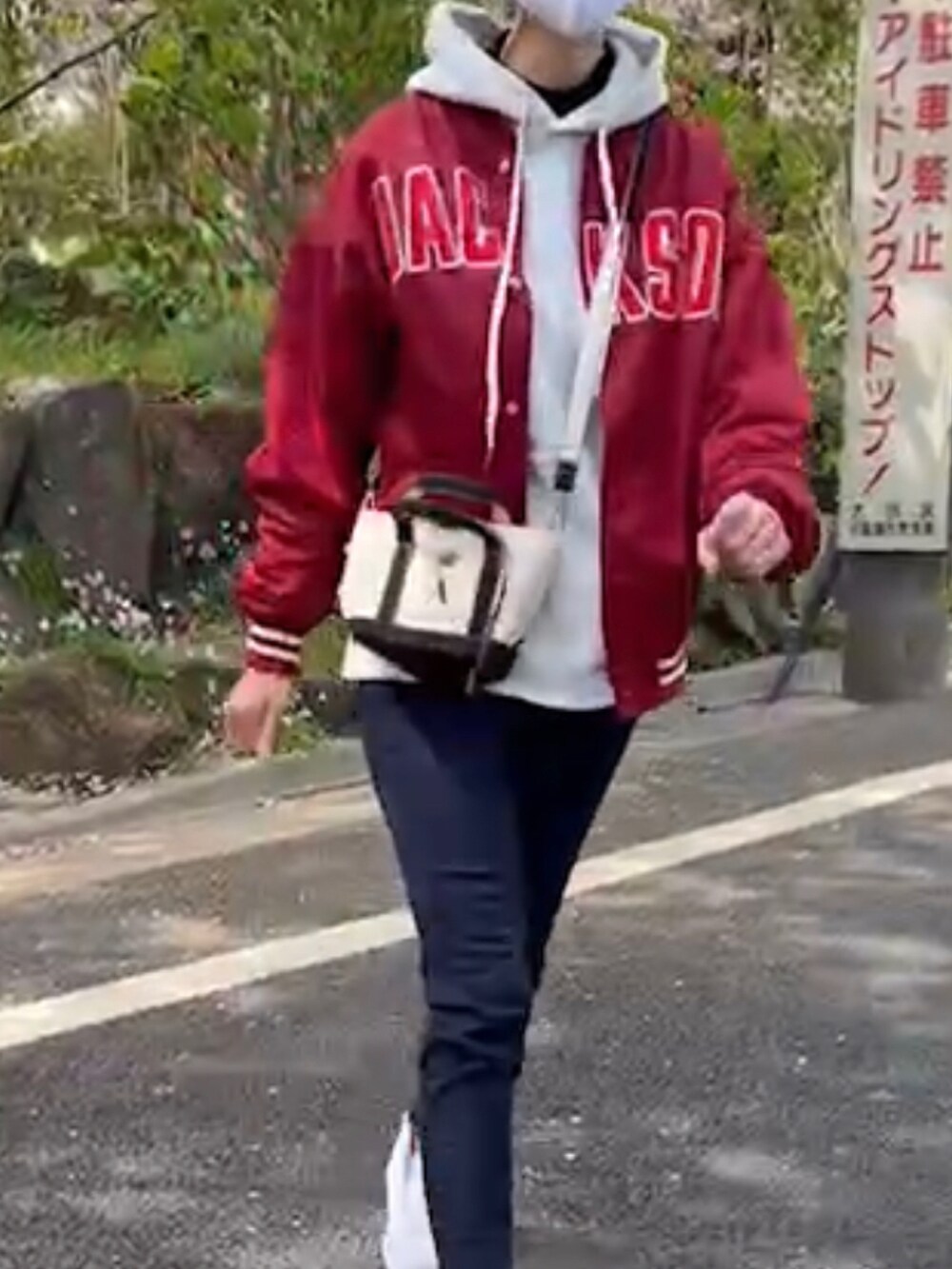 ホワイト系のバッグ、ブルー系のデニムパンツ、ホワイト系のスニーカーを着用したレディースの春コーディネートの3枚目の写真