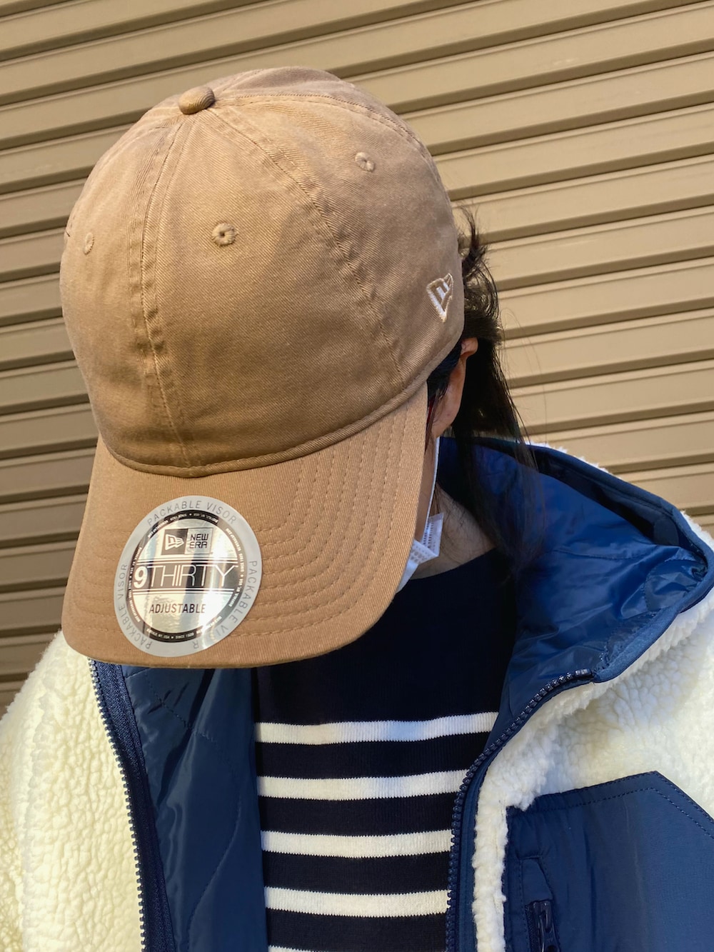 ブルー系のニット/セーター、ホワイト系のブルゾン、ブルー系のデニムパンツを着用したレディースの秋コーディネートの4枚目の写真