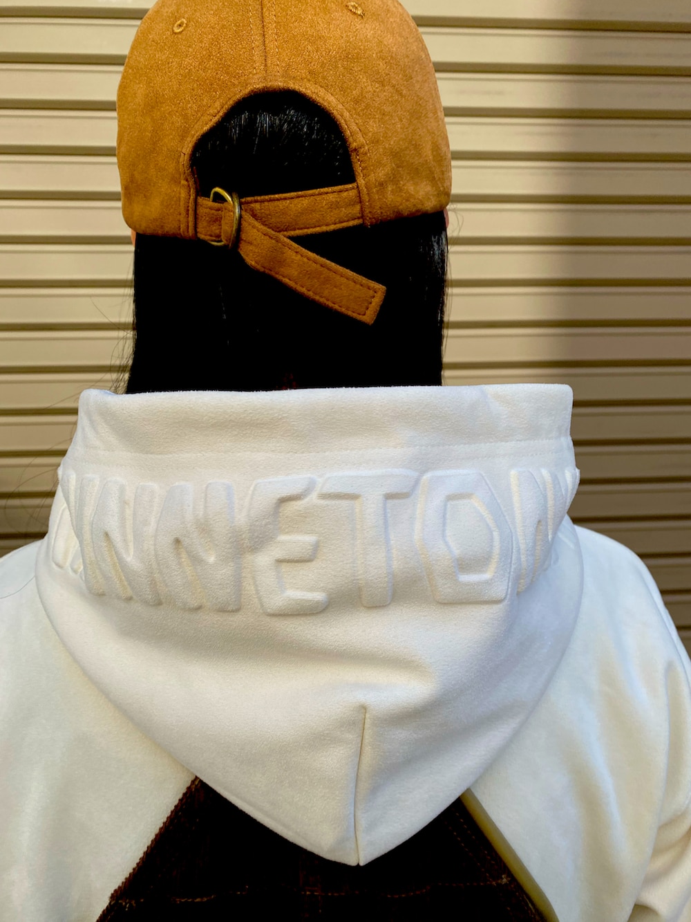 ホワイト系のパーカー、ベージュ系のショルダーバッグ、ブラウン系のサロペット/オーバーオールを着用したレディースの秋コーディネートの2枚目の写真