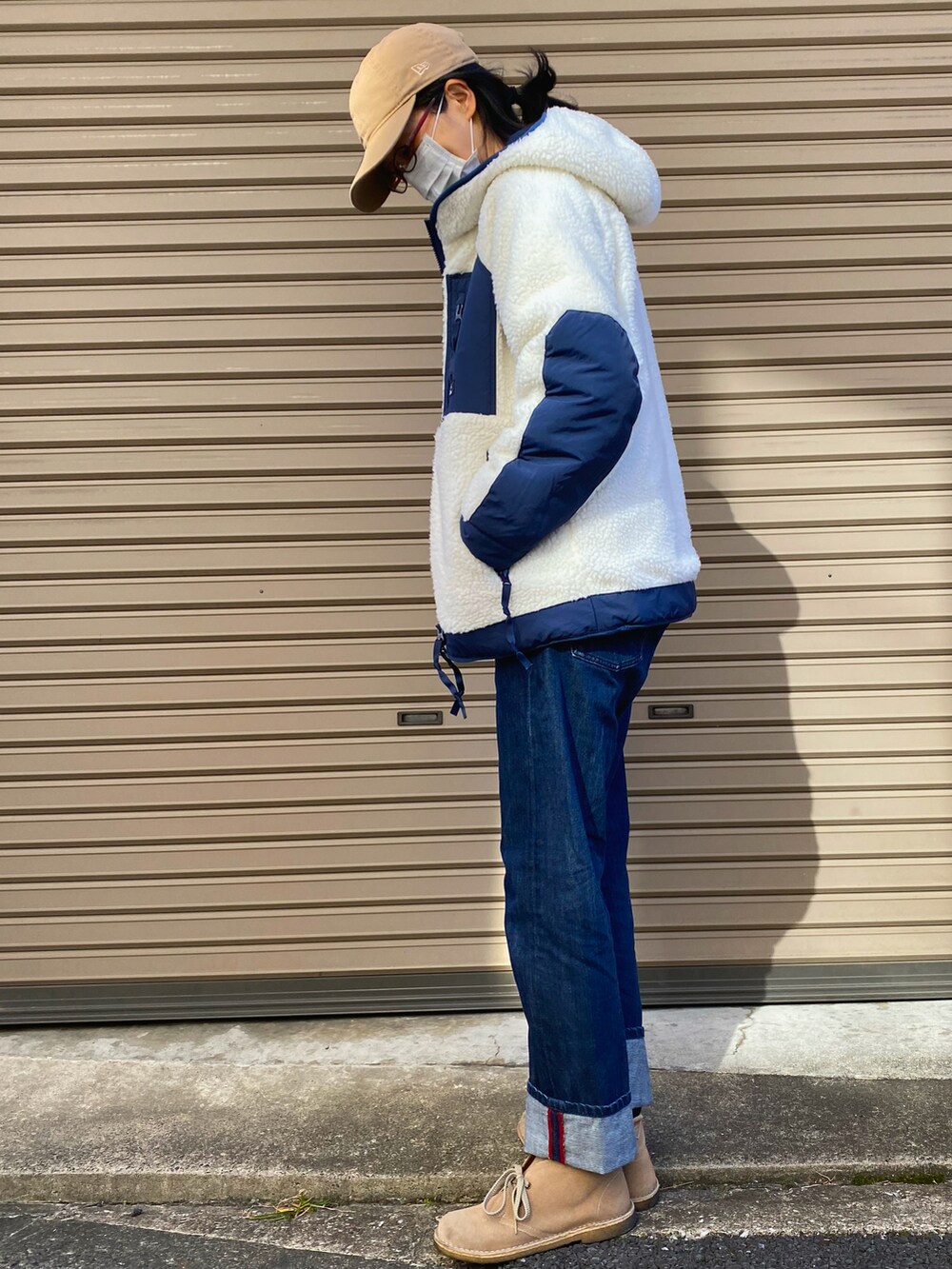 ブルー系のニット/セーター、ホワイト系のブルゾン、ブルー系のデニムパンツを着用したレディースの秋コーディネートの3枚目の写真