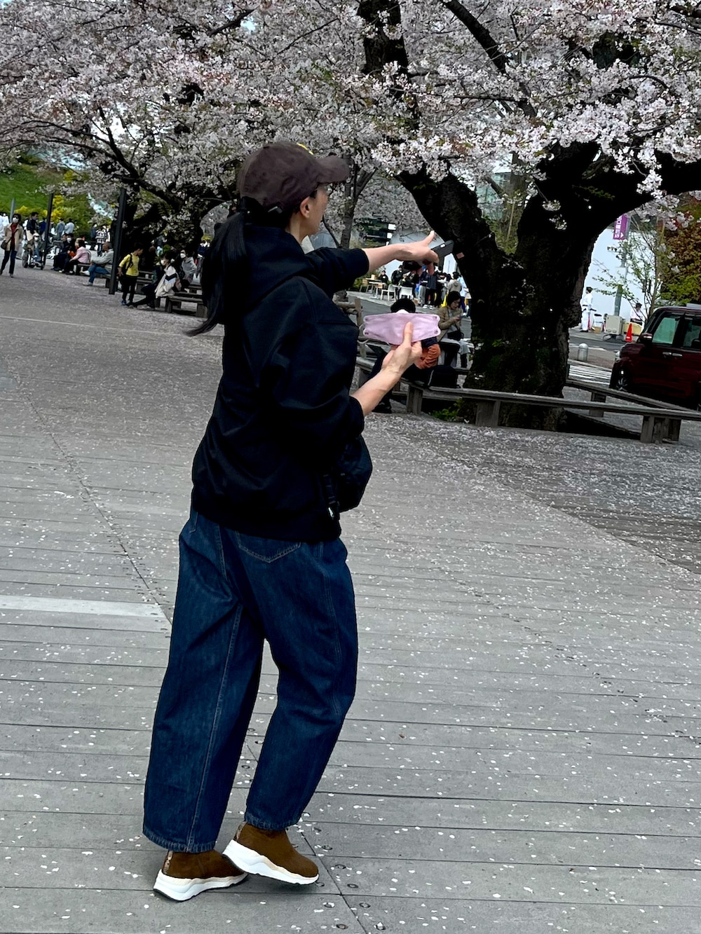 ブルー系のデニムパンツ、ブラウン系のブーツ、ブラウン系のキャップを着用したレディースの春コーディネートの2枚目の写真