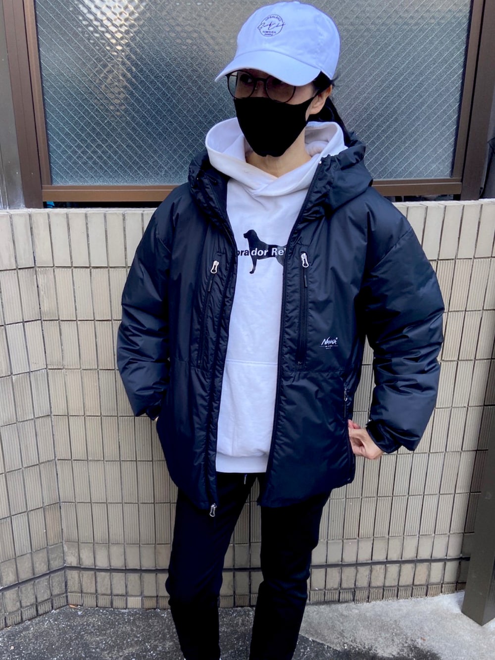 ブラック系のダウンジャケット/コート、ホワイト系のスニーカー、ホワイト系のパーカーを着用したレディースの冬コーディネートの2枚目の写真