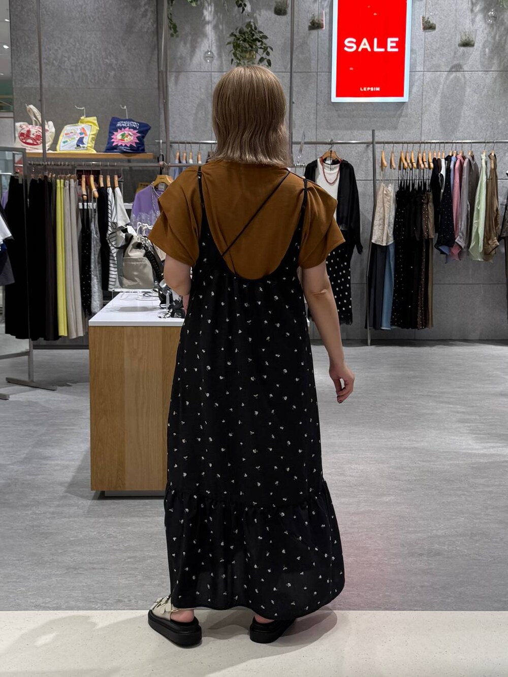 ブラック系のワンピース、ホワイト系のサンダル、イエロー系のTシャツ/カットソーを着用したレディースの夏コーディネートの3枚目の写真