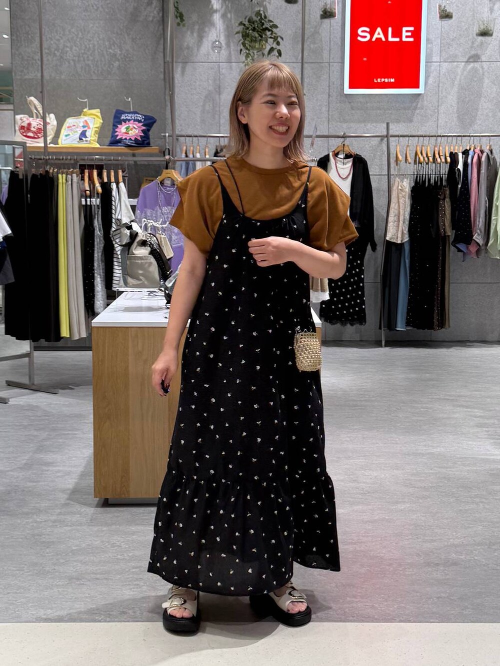 ブラック系のワンピース、ホワイト系のサンダル、イエロー系のTシャツ/カットソーを着用したレディースの夏コーディネートの5枚目の写真