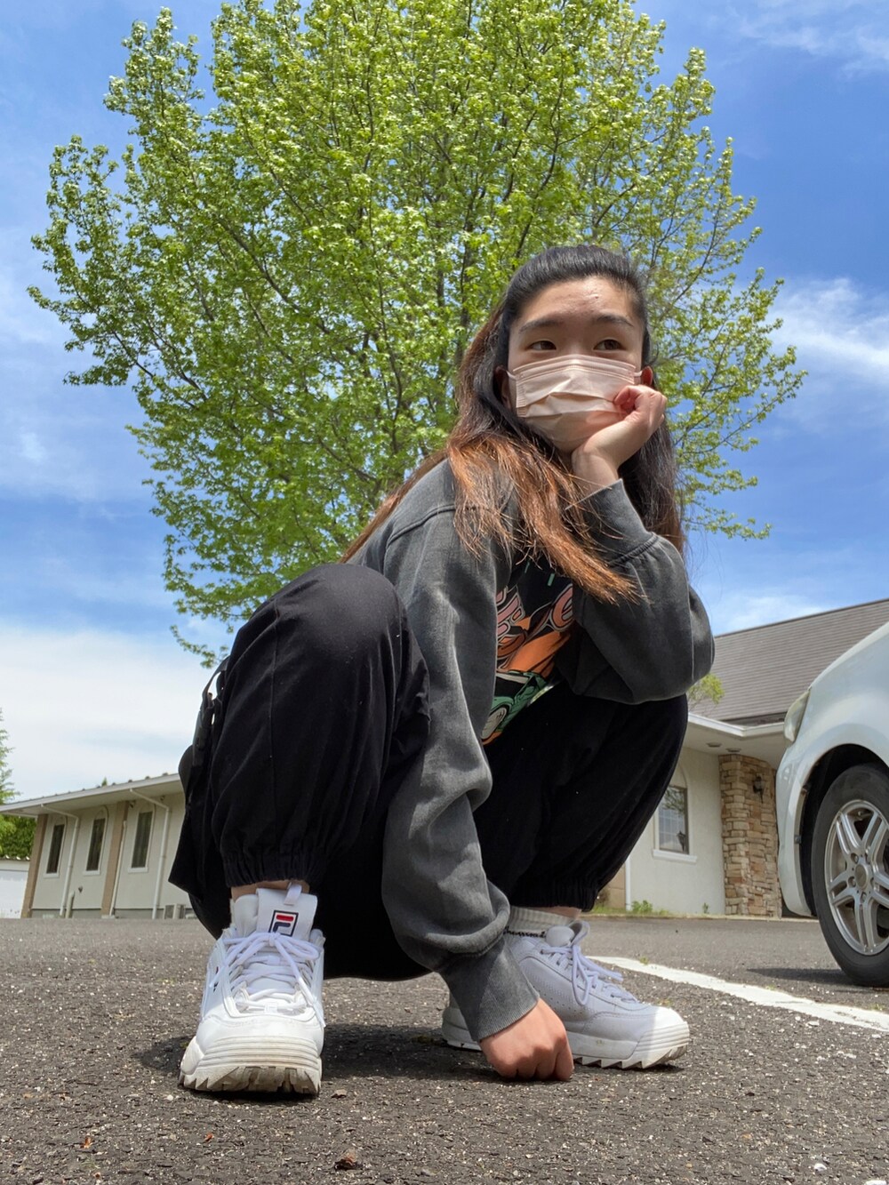 ブラック系のトップス、ブラック系のパンツ、ホワイト系のスニーカーを着用したレディースの春コーディネートの2枚目の写真