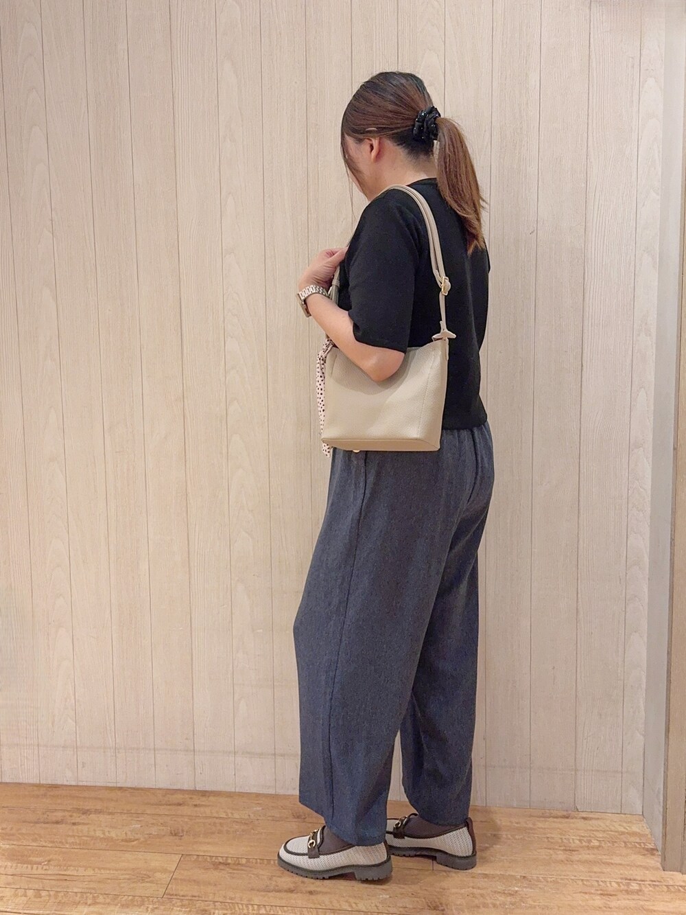 ブラウン系のパンプス、ベージュ系のショルダーバッグ、ブルー系のその他パンツを着用したレディースの春コーディネートの2枚目の写真