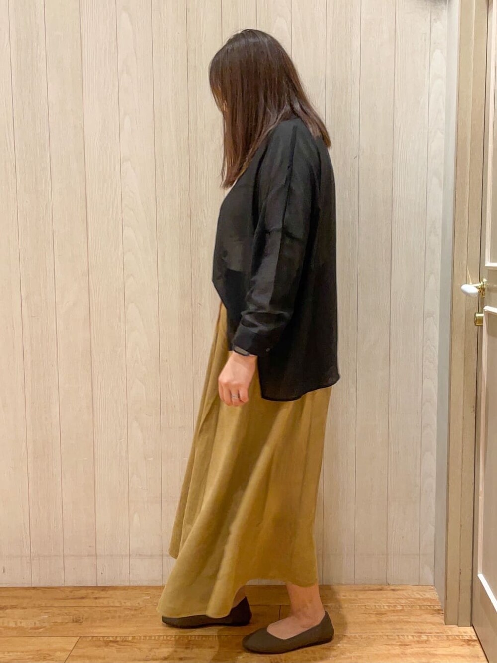 ブラウン系のパンプスを着用したレディースの秋コーディネートの2枚目の写真