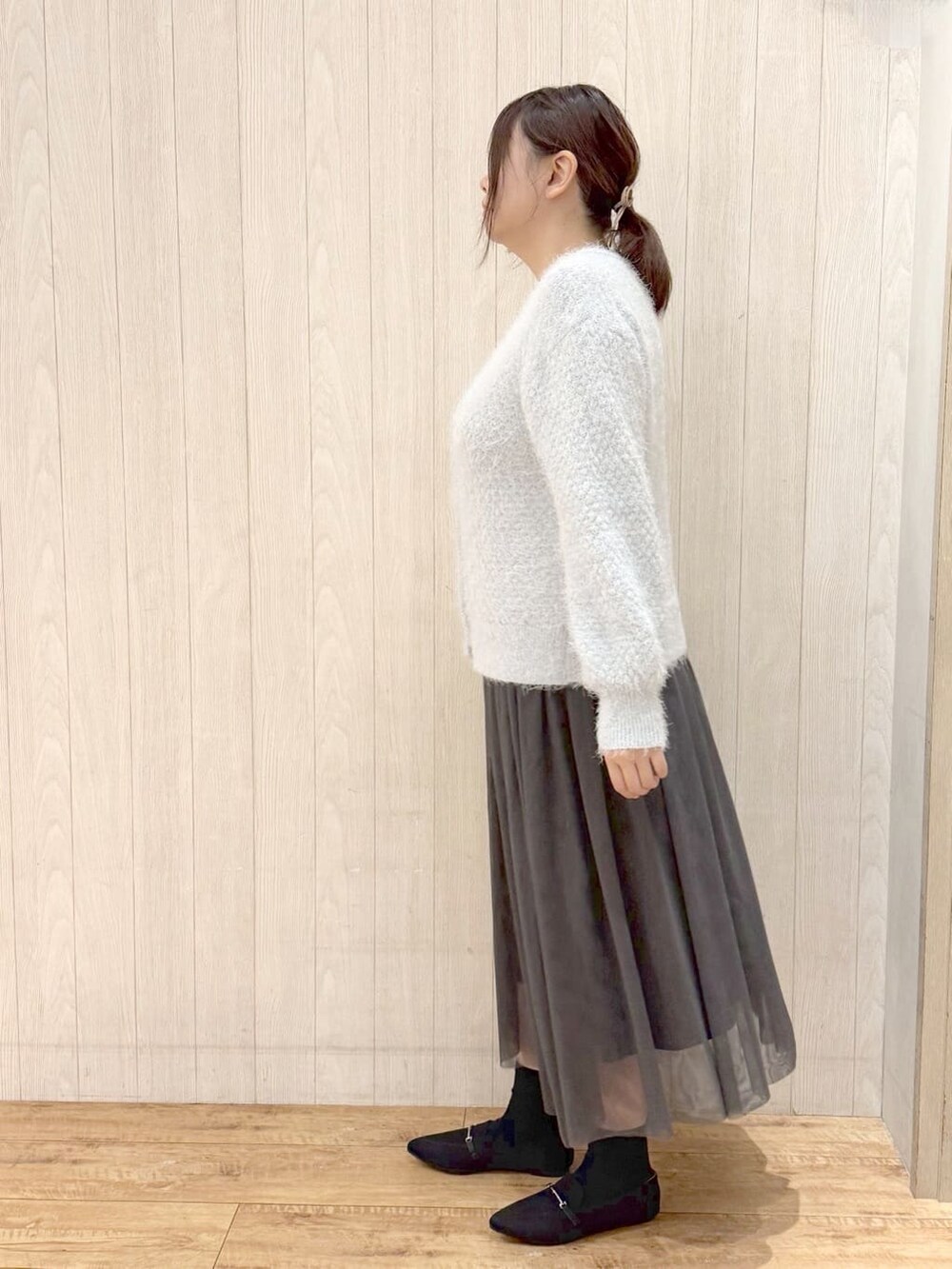 ブルー系のカーディガン/ボレロ、グレー系のスカート、ブラック系のその他シューズを着用したレディースの冬コーディネートの2枚目の写真