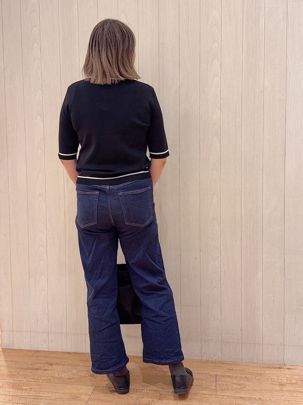ブラック系のカーディガン/ボレロ、ブルー系のデニムパンツ、ブラック系のパンプスを着用したレディースの夏コーディネートの3枚目の写真