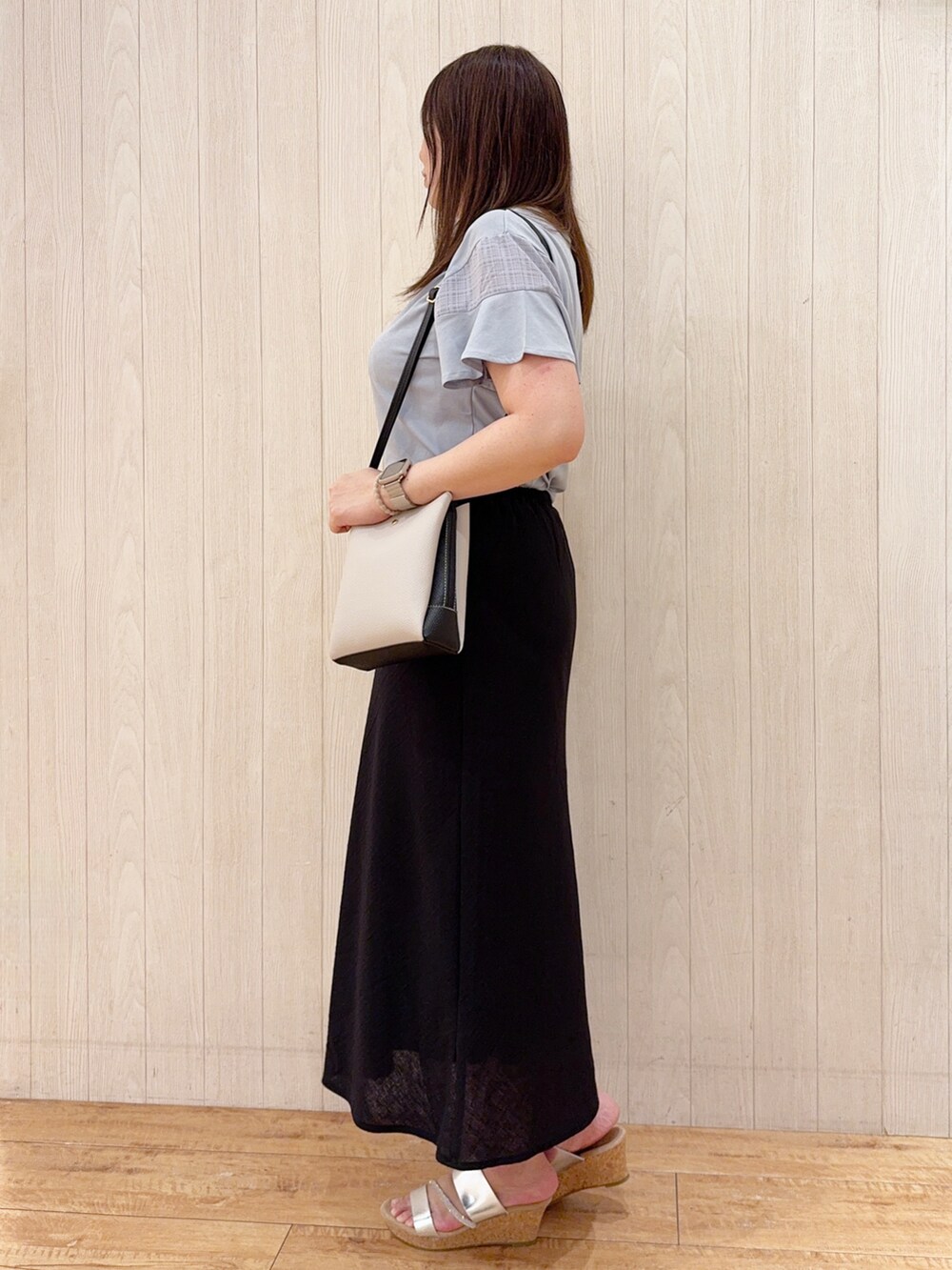 ブルー系のTシャツ/カットソー、ブラック系のスカート、シルバー系のサンダルを着用したレディースの夏コーディネートの2枚目の写真