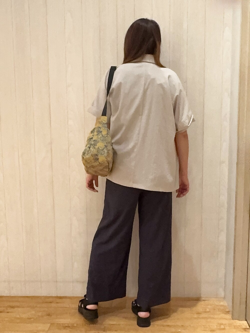 ベージュ系のテーラードジャケット、ブルー系のニット/セーター、グレー系のその他パンツを着用したレディースの夏コーディネートの3枚目の写真