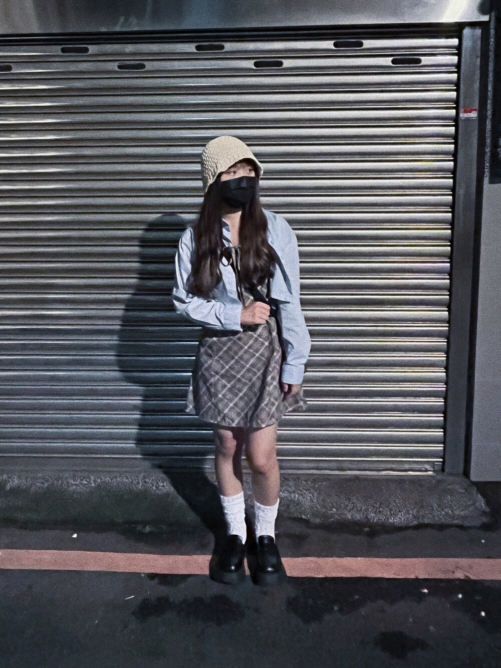 グリーン系のバッグ、ブルー系のトップス、ホワイト系のレッグウェアを着用したレディースの夏コーディネートの2枚目の写真