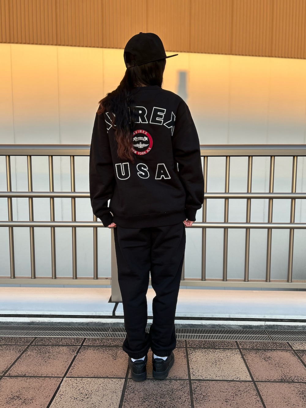ブラック系のスウェット、ブラック系のスウェットパンツ、ブラック系のキャップを着用したレディースの冬コーディネートの2枚目の写真