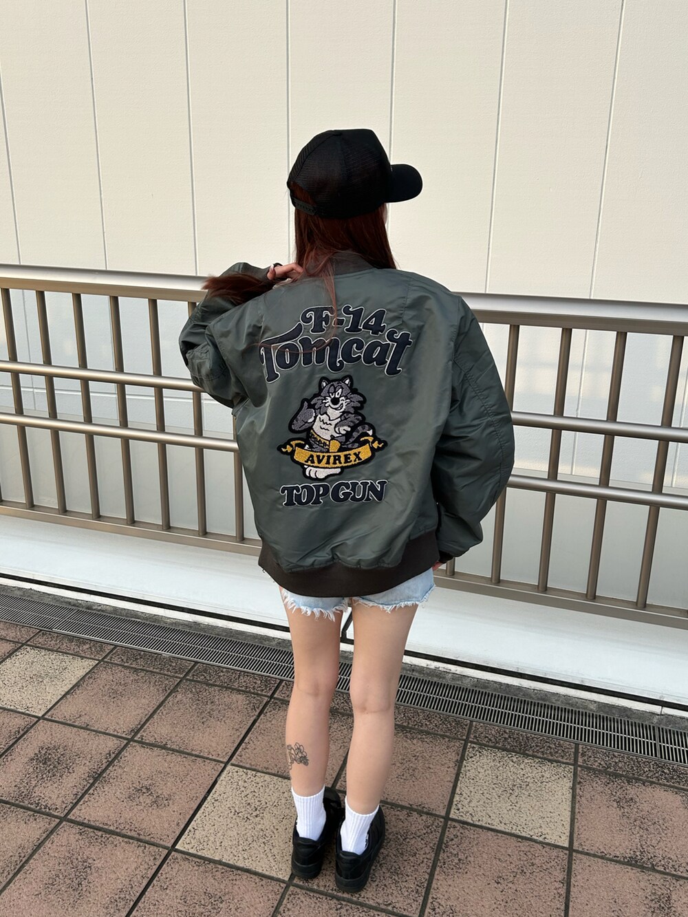 ホワイト系のTシャツ/カットソー、グリーン系のMA-1、ブラック系のキャップを着用したレディースの秋コーディネートの2枚目の写真