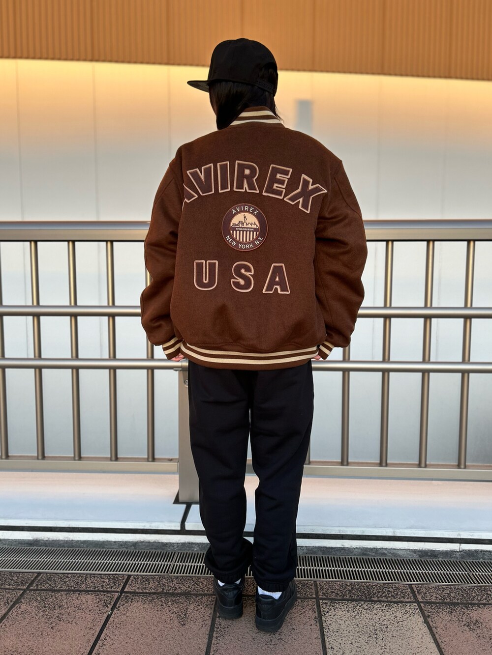 ブラック系のスウェット、ブラック系のスウェットパンツ、ブラウン系のスタジャンを着用したレディースの冬コーディネートの2枚目の写真