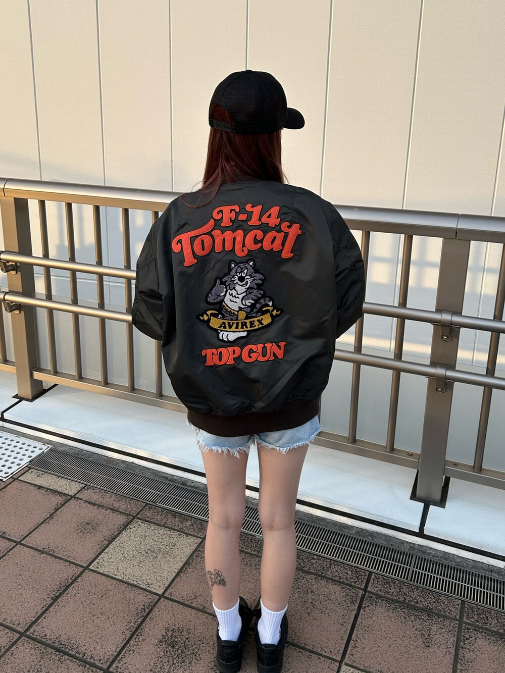 ホワイト系のTシャツ/カットソー、グリーン系のMA-1、ブラック系のキャップを着用したレディースの秋コーディネートの2枚目の写真